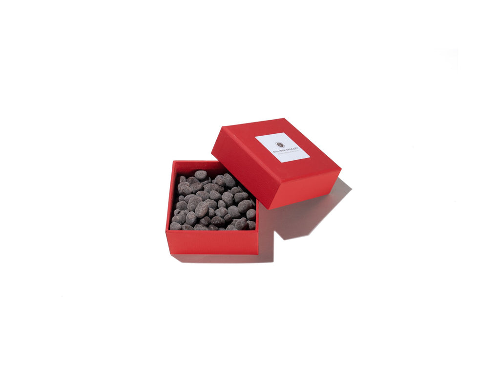 Gift box of roasted pistachios coated in dark choclated and dusted in icing sugar
